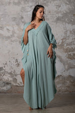 A versatile, earthy goddess dress that embodies boho-chic style. Crafted from the softest cotton fabric, this garment offers both comfort and a fashion statement. The dress can be worn in two distinct styles, either as a kaftan or a sultry dress, with a simple change in the way you put it on. Its natural and ethereal design exudes a warm, comforting feeling against your skin, making it a must-have addition to your wardrobe for those seeking a harmonious blend of style and comfort.