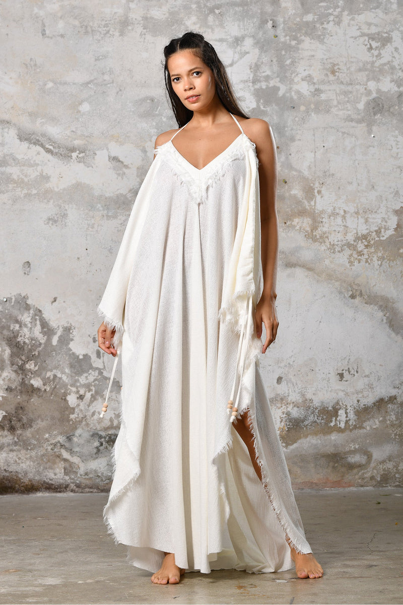 A versatile, White earthy goddess dress that embodies boho-chic style. Crafted from the softest cotton fabric, this garment offers both comfort and a fashion statement. The dress can be worn in two distinct styles, either as a kaftan or a sultry dress, with a simple change in the way you put it on. Its natural and ethereal design exudes a warm, comforting feeling against your skin, making it a must-have addition to your wardrobe for those seeking a harmonious blend of style and comfort.